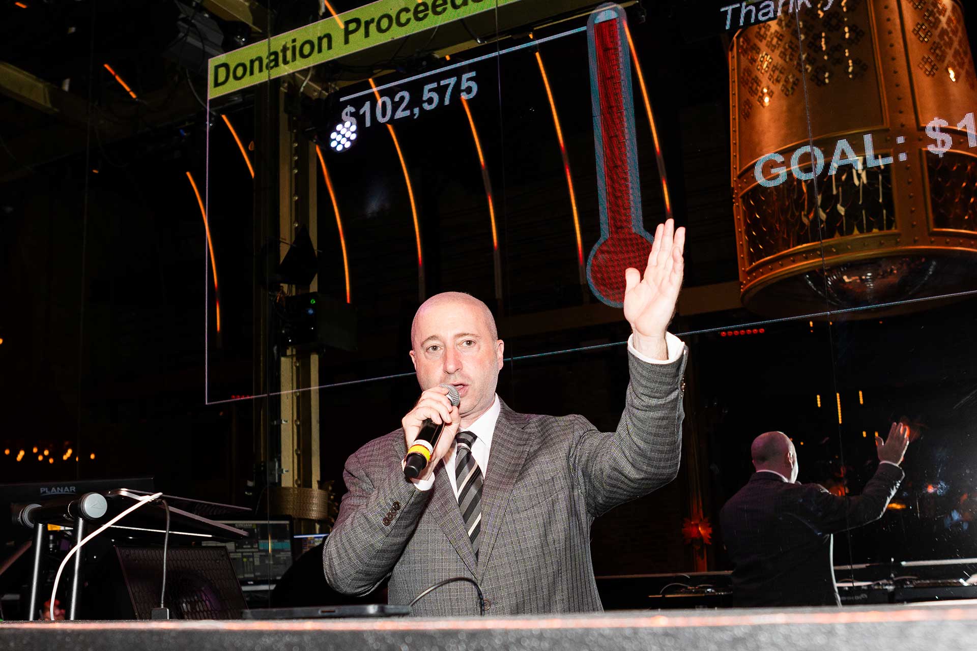 man speaking at a microphone at the 2023 Benefit for the TVMJD Foundation